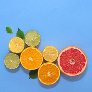 Cyan ya da mavi arka planda dilimlenmiş turunçgiller ve yeşil yapraklarla geçen yaz sahnesi. Düz yatıyordu yaratıcı kopya alanı