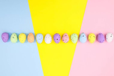 Sıraya dizilmiş yumurtalarla dolu renkli Paskalya arkaplanı. Düz konsept tatiller asgari konsept. Yaratıcı kopyalama alanı