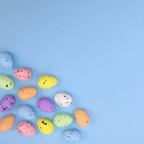 Pastel Mavi Arka Planda Paskalya Için Gökkuşağı Renkli Yumurtalar Düz — Stok fotoğraf