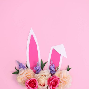 Bahar tatili yaratıcı geçmişi tavşan kulaklarıyla süslenmiş pastel pembe temalı çiçek. Yaratıcı kopyalama alanı Paskalya konsepti