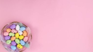 Paskalya tatillerinde ahşap sepeti ve canlı renkli yumurtaları olan yaratıcı pastel pembe fotokopi alanı. Spring Flat Yayın konsepti