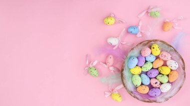 Renkli yumurtalar ve pastel pembe temalı Paskalya süslemeleri olan yaratıcı paskalya fotokopi alanı arka planınız kutlu olsun. Dümdüz uzanır