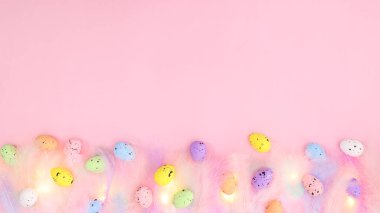 Renkli yumurtalarla birlikte pastel, parlak pembe arka planda rengarenk renkli tüyler. Bahar konsepti Yaratıcı kopyalama alanı Paskalya düzleşmesi