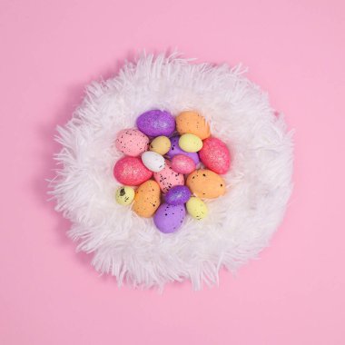 Renkli Paskalya yumurtaları, yaratıcı tüylü eko kürklü, pembe arka planda. Düz yatar minimal kopya alanı tebrik kartı