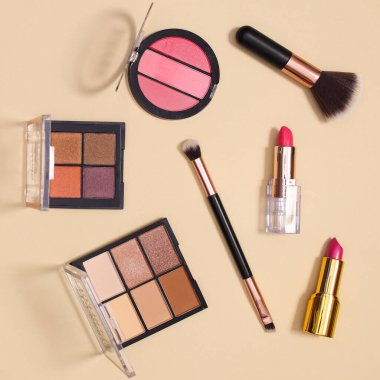 Pastel bej arka planda makyaj ürünleri ile yaratıcı yerleşim düzeni. Düz yatıyordu