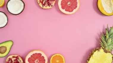 Summer tropic frame made with exotic fruits on pastel pink background. Creative copy space. Flat lay stop motion