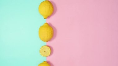 Pastel pembe ve cyan arka planda limon taşımak çok yaratıcı. Yaz tropik duruş hareketi. Uzayı düz olarak kopyala