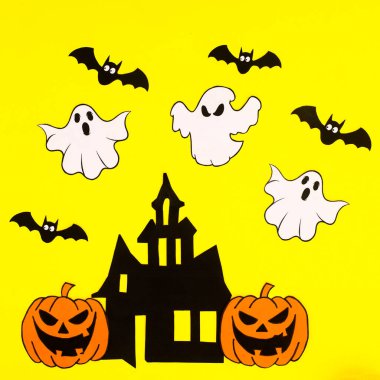 Yellow background with creative arrangement of creepy Halloween stickers. Flat lay