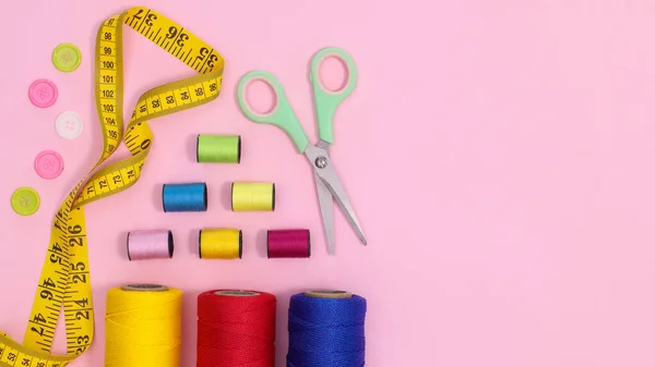 Sewing supplies and asccessories on pastel pink background with copy space. Flat lay