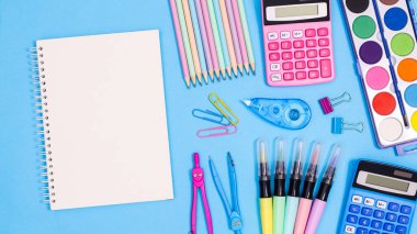 Open notebook copy space with school stationery on pastel blue background. Flat lay. Back to school concept
