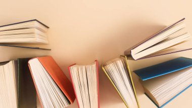 Pastel beige background with vintage colorful books. Flat lay copy space