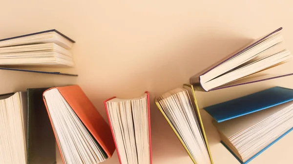 Pastel beige background with vintage colorful books. Flat lay copy space