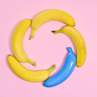 Creative frame made of ripe bananas in circle on pastel pink background. Flat lay copy space