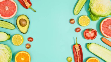 Copy space background with sliced fresh fruits and vegetables on cyan theme. Flat lay HEalthy lifestyle