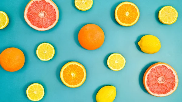 Summer creative oranges, lemons and grapefruits pattern on bluebackground. Tropic citrus fruits concept. Flat lay