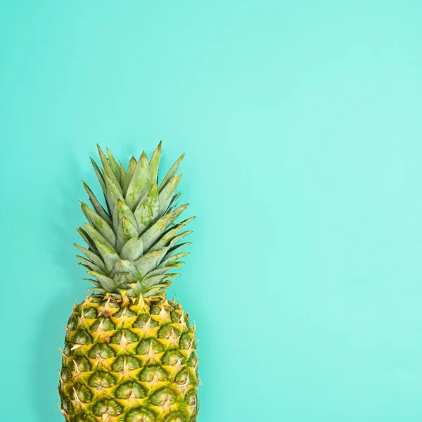 Fresh ripe pineapple on pastel blue background. Flat lay summer concept. Copy space
