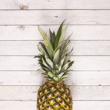 Fresh ripe pineapple on wooden backgorund. Flat lay. Summer fruits concept