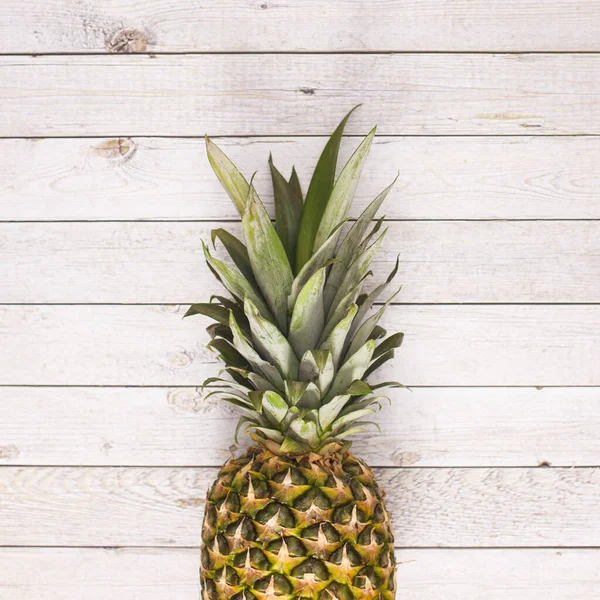 Fresh ripe pineapple on wooden backgorund. Flat lay. Summer fruits concept