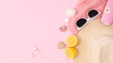 Beach accessories on pastel pink background with copy space. Summer concept flat lay