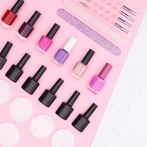 Make up set and nail polishes pastel pink background with copy space. Flat lay beauty concept