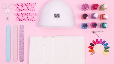 Manicure set and nail cosmetics products on pastel pink background. Flat lay