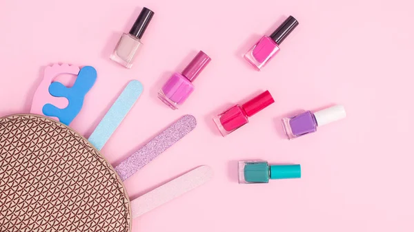 Cosmetics kit and nail manicure set on pastel pink background. Flat lay