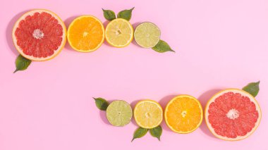 Citrus summer fruits layout on pastel pink background. Flat lay