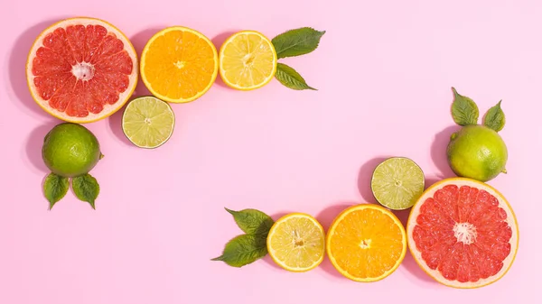 Citrus summer fruits frame composition on pastel pink background with copy space. Flat lay