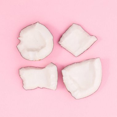 Sliced fresh coconut on pastel pink background. Flat lay