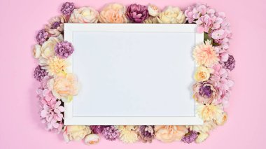 Copy space white paper with pink romantic flowers on pastel pink background. Flat lay VAlentine's day concept