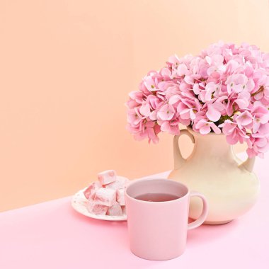 Romantic dessert with cup of tea and flowers in vase
