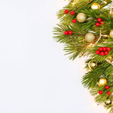 Beyaz fotokopi arka planında kırmızı ve altın süslerle süslenmiş çam dalları. Düz yatıyordu