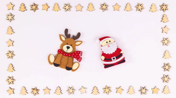 白色背景的木制饰物框架和圣诞老人和驯鹿贴纸 平躺在床上 — 图库照片