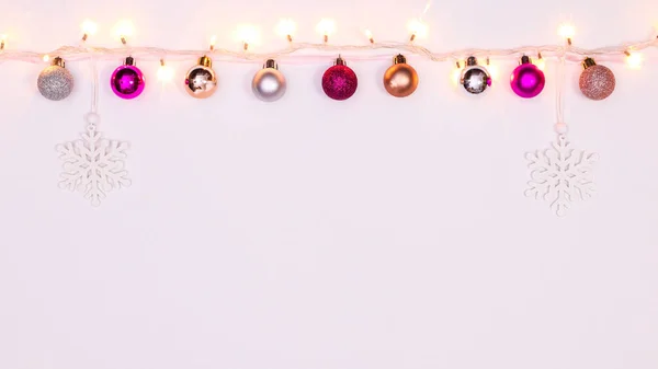 白色背景上挂着富有创意的圣诞彩灯和装饰品的花环 平躺在床上 — 图库照片