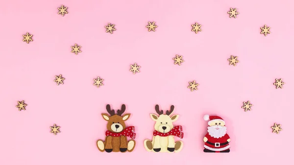 圣诞粉红背景 圣诞老人和两个驯鹿 平躺在床上 — 图库照片
