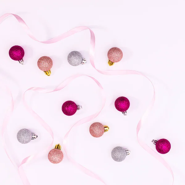 Pink and silver ornaments with ribbon arrangement on white background. FLat lay