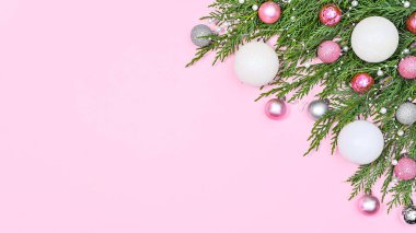 Fotokopi alanı ve pembe ve beyaz süslemelerle süslenmiş çam dalları olan pastel pembe arkaplan. Düz yatıyordu