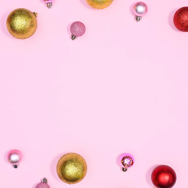 金色的红色和粉色装饰圣诞球在粉红的复制空间背景上 平躺在床上 — 图库照片