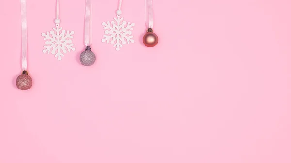 圣诞装饰品和雪花挂在粉红的背景上 并留有复制空间 — 图库照片