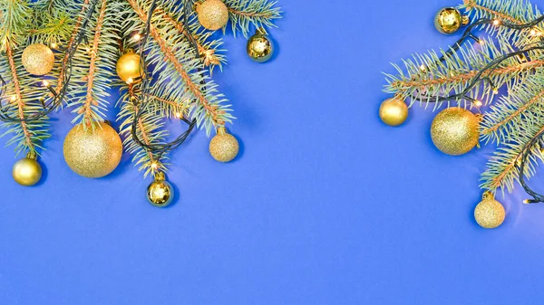Goldene Ornamente Auf Tannenzweigen Mit Dekorativen Lichtern Auf Blauem Hintergrund — Stockfoto