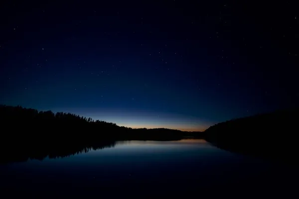 Gece yıldızlı gökyüzü gölün üzerinde