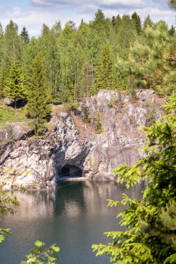 Ormandaki kayaların arasında mavi bulutlu gökyüzü