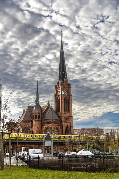 Berlín pohled cihlový kostel s žlutým metrem vpředu na b — Stock fotografie