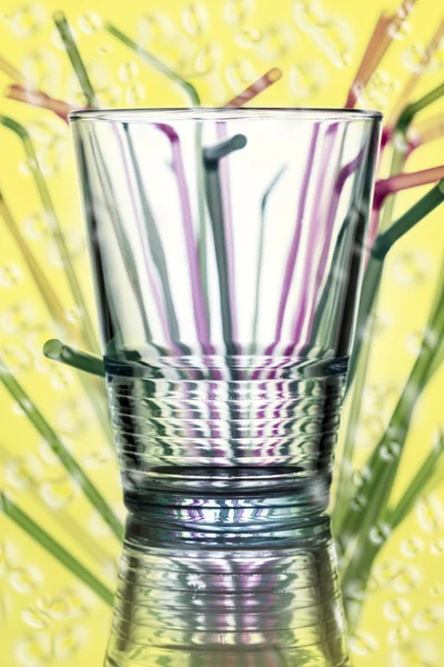 Water glass with straws in the background — Stock Photo, Image