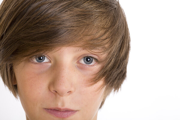 Closeup of a cute teenage boy smiling into the camera, isolated