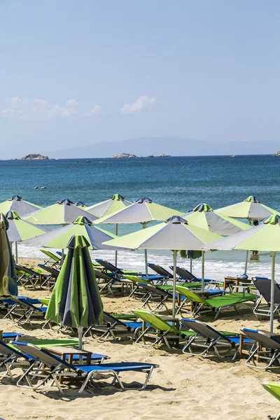 A groupe of green parasols and sunlounger with blue ocean in bac — Stock Photo, Image