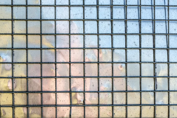 Metal grid with mirroring surface in background — Stock Photo, Image