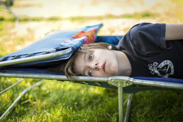 Soñando adolescente chico tendido en un sunlounger — Foto de Stock