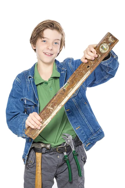 Lächelnder Junge mit Werkzeug im Gürtel, das einen Wasserstand in der Hand hält — Stockfoto