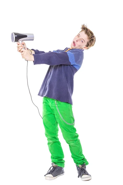 Casual teenage boy is fighting with a hair dryer, isolated on wh — Stock Photo, Image